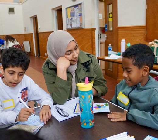 A mentor and two children engaged in an activity 