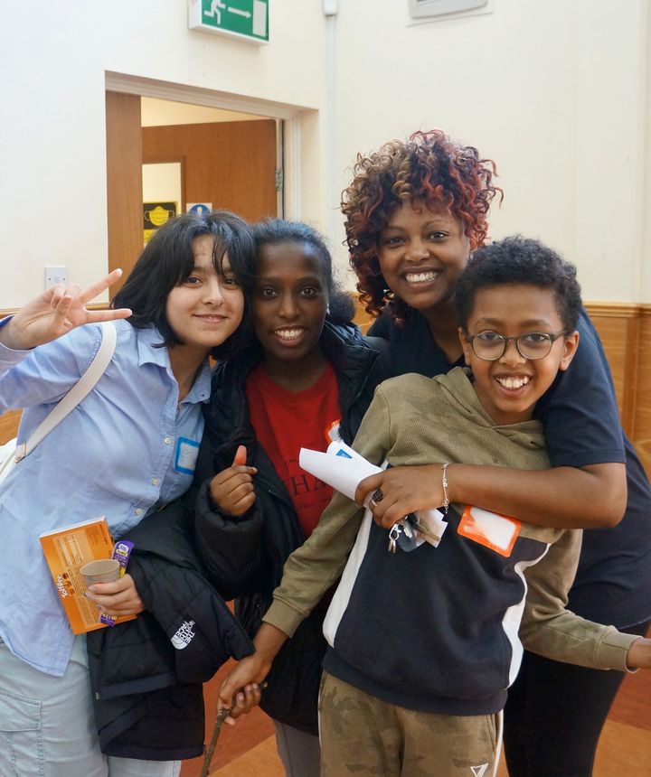 Four people huddled together smiling at the camera during a WISE Camp