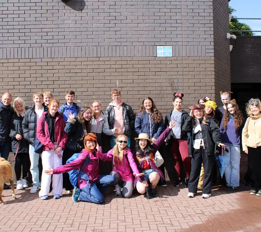 A group photo of volunteers, staff and community members during a fundraising activity.